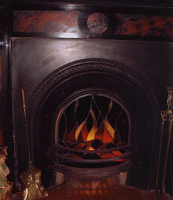 Fireplace with stained glass panel fitted to simulate a real fire when not being used